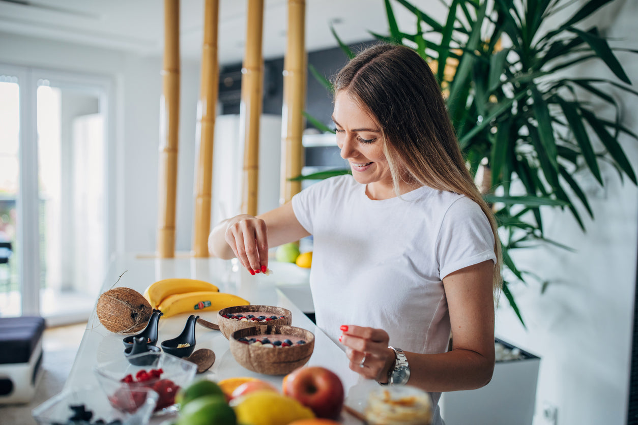 Woman using chia seeds on her breakfast smoothie bowl